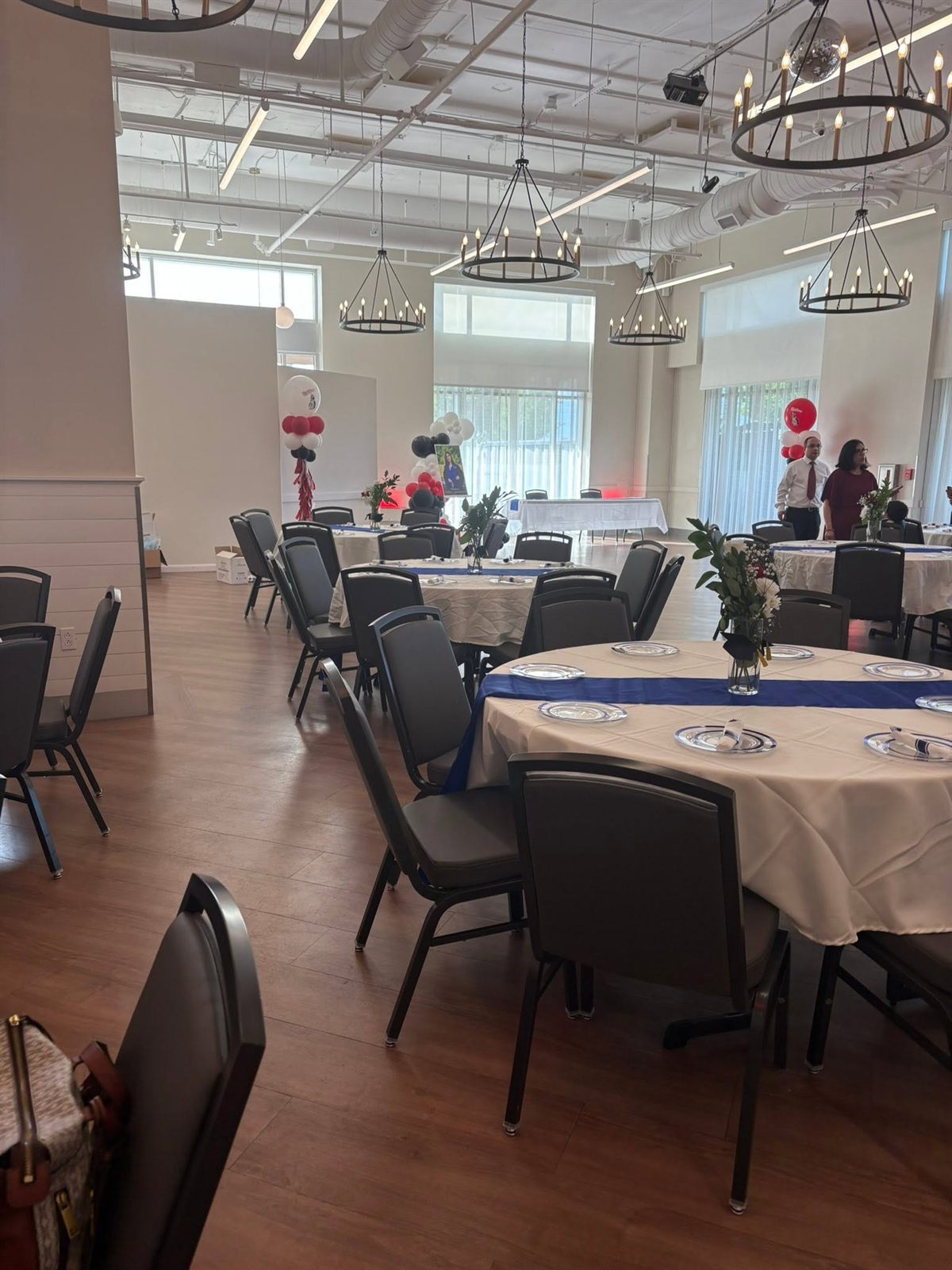 Banquet hall set with round tables, navy runners and chandeliers for a seated reception. Corporate Events by EPIC Parties in Middle Tennessee.